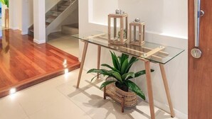 Ein modernes Interieur mit einem Glastisch, einem Spiegel und einer Treppe.