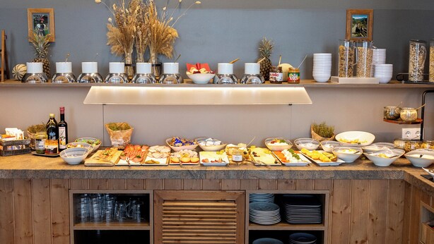 A buffet setup with various food items and condiments. - DORMERO Hotel Freiburg (Freiburg im Breisgau)