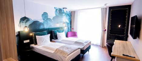 A hotel room with a bed, bedside tables, a desk, a chair, a TV, and a large window.