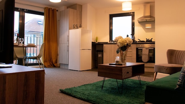 Un espacio habitable compacto con kitchenette, comedor y zona de estar.