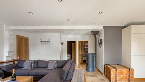 A modern living room with a sectional sofa, wooden coffee table, and a fireplace. - Spacious apartment 6 pers, terrace sauna close to slopes (Val Thorens)