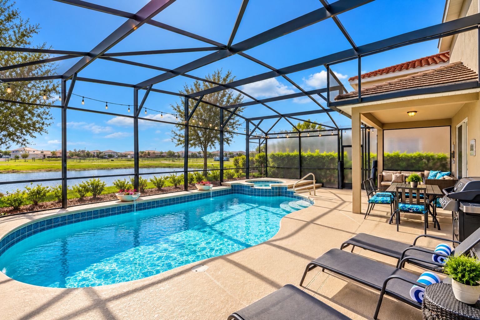 Piscina com hidromassagem, área de estar ao ar livre e vista para um lago.