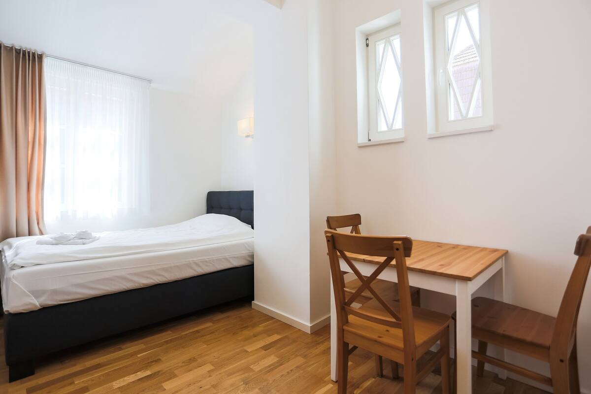 Ein Schlafzimmer mit einem Bett, einem Holztisch und zwei Stühlen.
