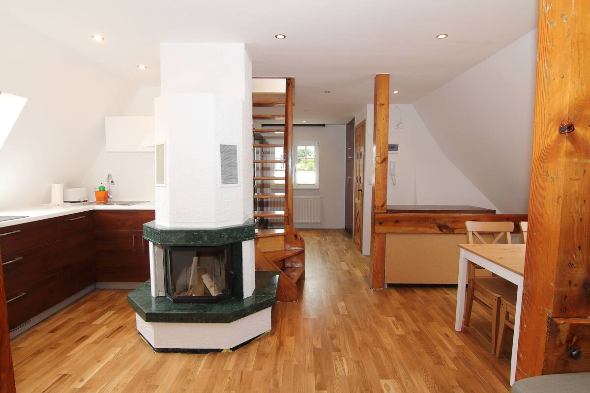 Eine moderne Küche mit einer zentralen Kochinsel, Holzschränken und einem integrierten Kamin.