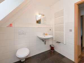 Een bad/douchecombinatie, een haardroger, handdoeken, zeep