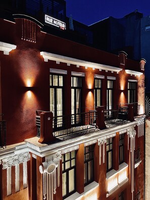Um edifício com estilo arquitetônico clássico, com uma entrada destacada, varanda e a placa