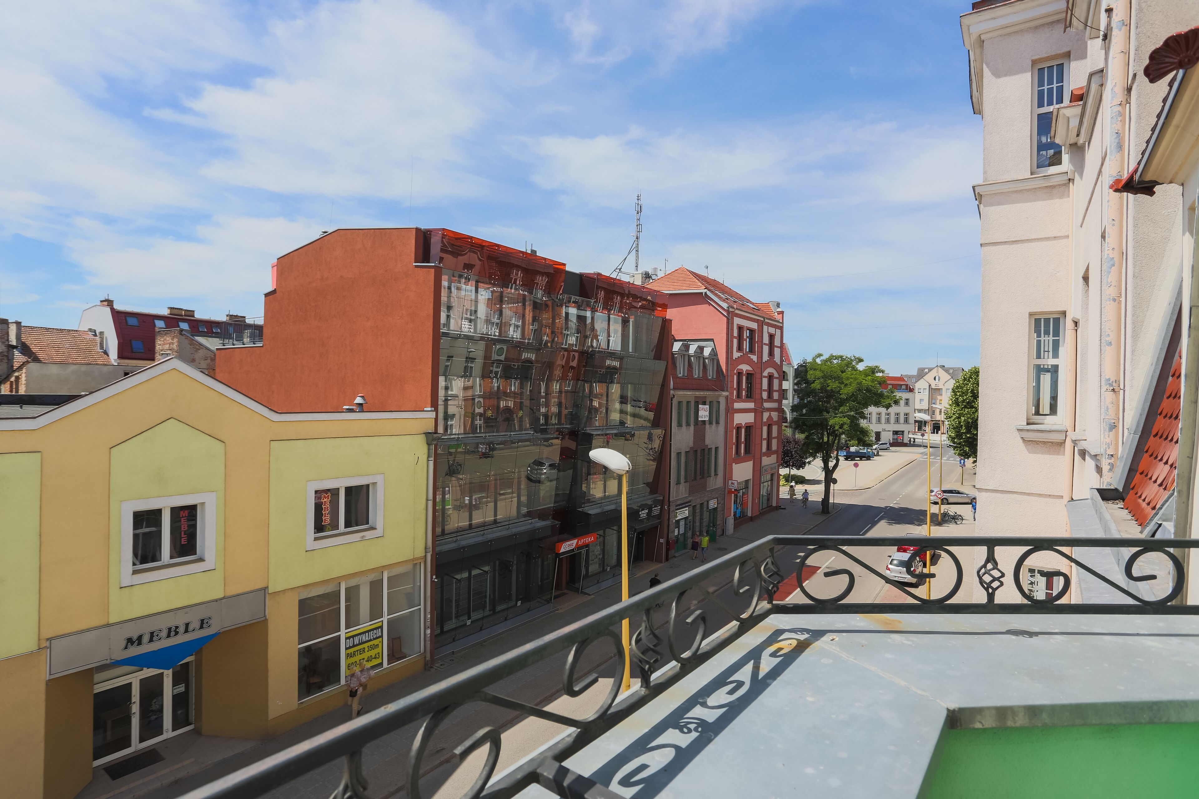 A multi-story building with a ground-floor shop named "MEBLE" and a visible staircase leading to an upper floor.
