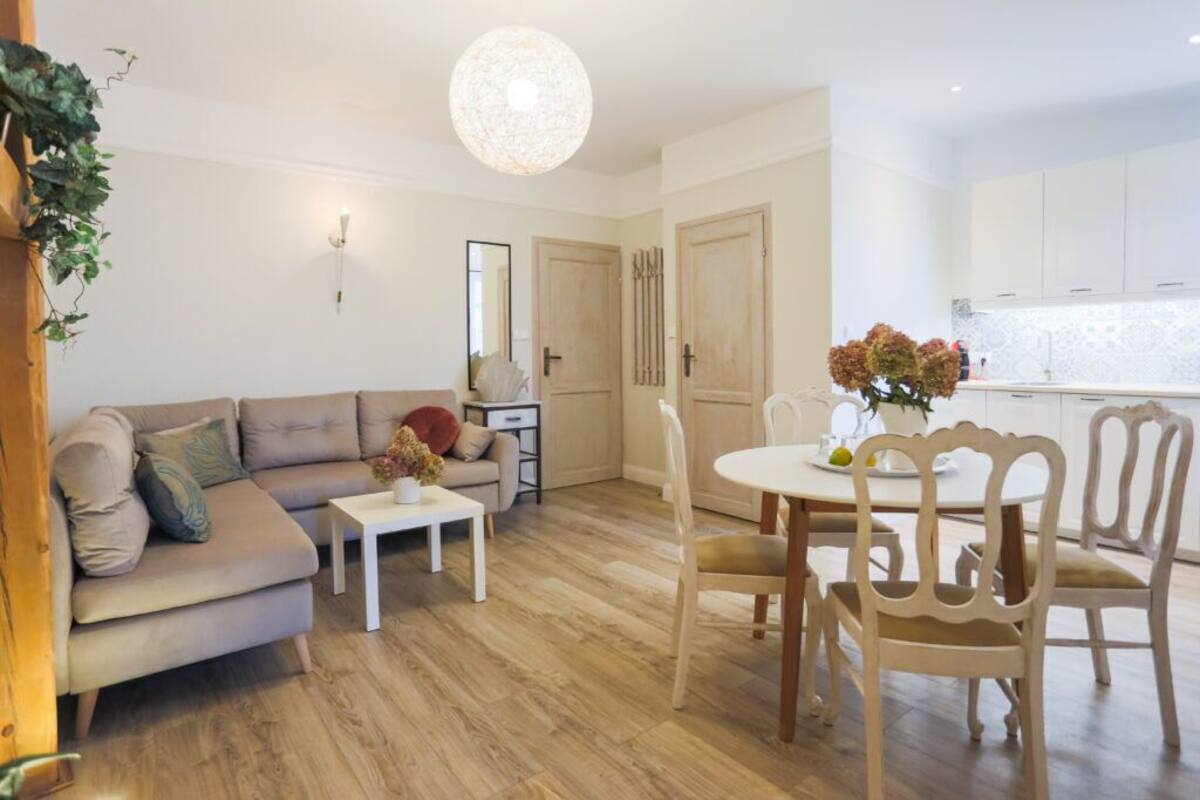 A living room with a sofa, coffee table, and dining table with chairs.