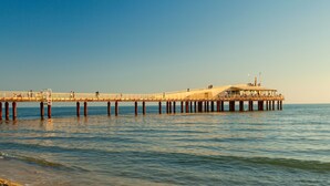 A pier extending into the water with a building on it.