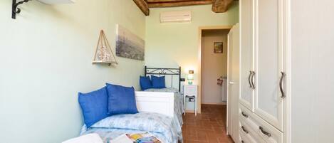 A bedroom with a bed, bedside table, and wardrobe.