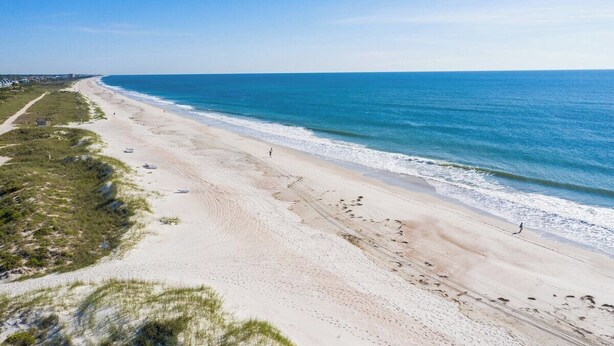 A wide beach with clear blue water and a sandy shore. - Spacious 3BR ocean-view condo, beautifully decorated! (Fernandina Beach)