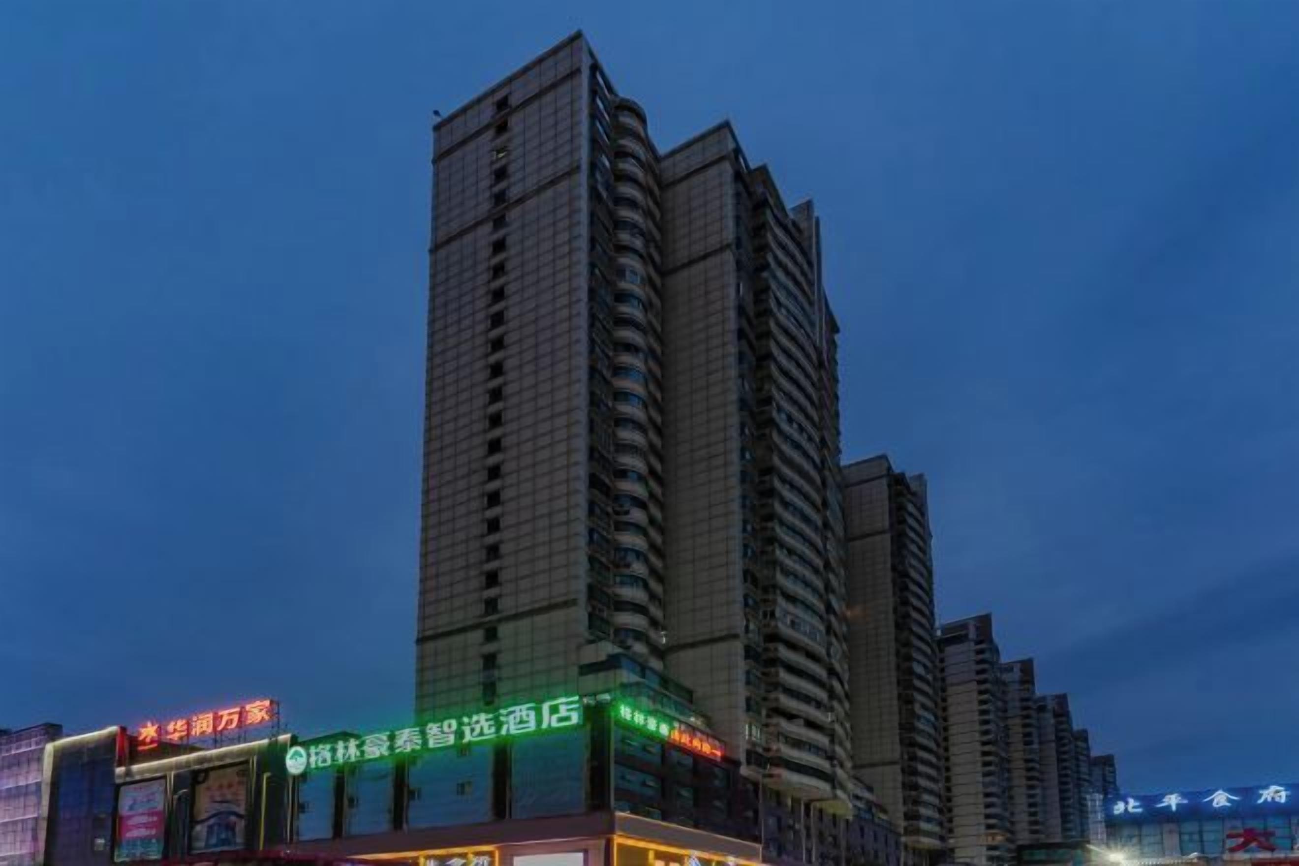 A high-rise building with multiple floors, featuring illuminated signage and windows.