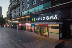 A hotel facade with multiple storefronts, including a prominent sign for a hotel. - GreenTree Inn (Hefei Datang International Honggang Metro Station) (Hefei)