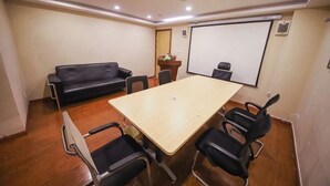 A conference room with a wooden table, black chairs, a black sofa, and a whiteboard. - GreenTree Inn (Hefei Datang International Honggang Metro Station) (Hefei)