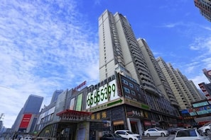 Um edifício com vários andares e fachada comercial, com um número de telefone em destaque.