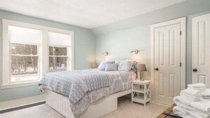 A bedroom with a bed, bedside tables, a window, and a door. - Sunday River Getaway (Newry)