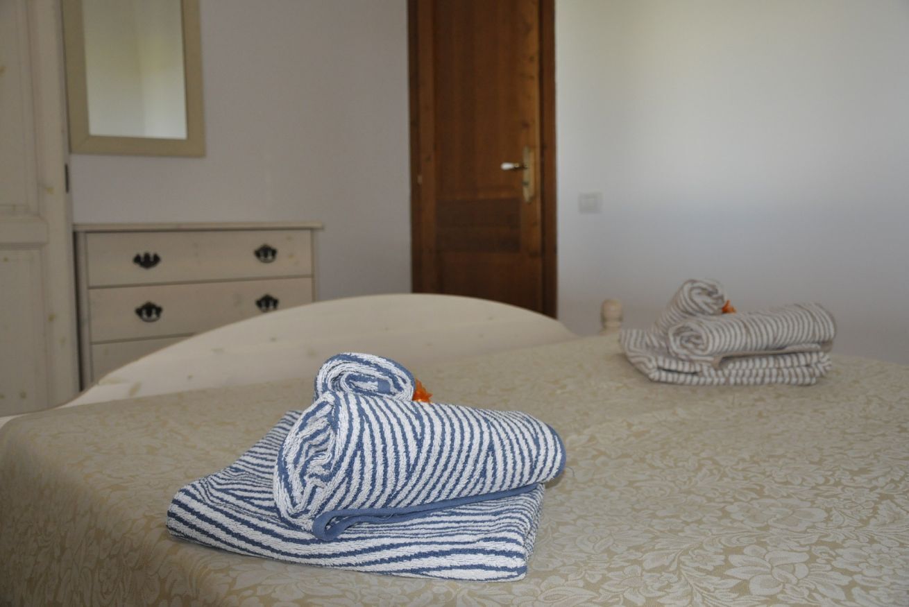 Un dormitorio con cama, cómoda y puerta.