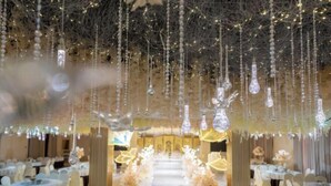 A banquet hall with round tables, a central aisle, and hanging light fixtures. - Xingpeng International Hotel (Huayuan)