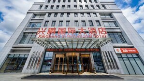 A modern hotel building with a prominent sign reading "Xingda International Hotel". - Xingpeng International Hotel (Huayuan)