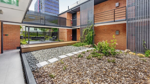 A modern building with a brick facade, a covered outdoor seating area, and a gravel pathway. - Spring Hill Inn (Spring Hill)