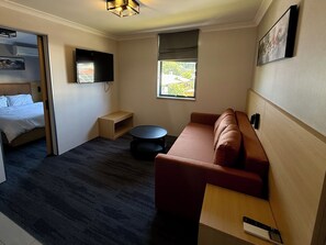 Neljän hengen deluxe-huone | Työpöytä, kannettavalle tietokoneelle sopiva työtila, pimennysverhot