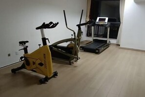 A home gym with an elliptical trainer, a treadmill, and a stationary bike.