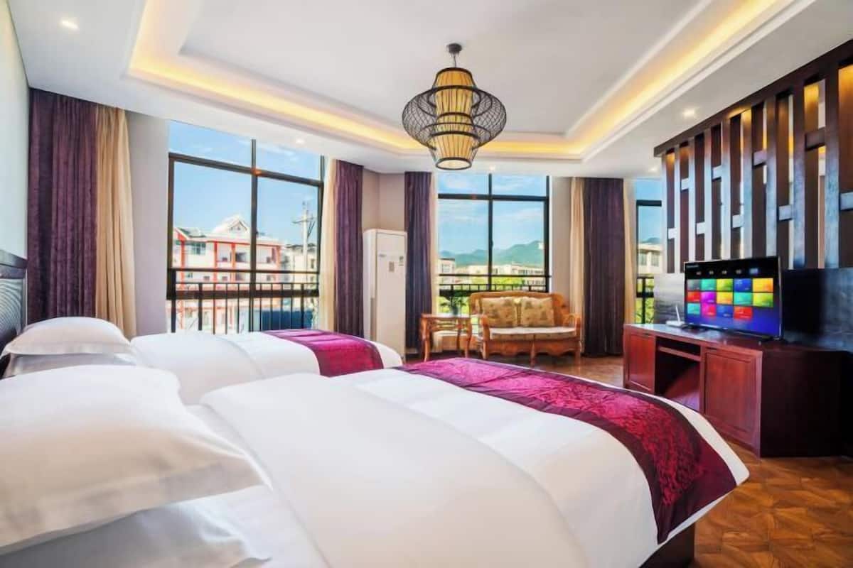 Een hotelkamer met een groot bed, een televisie, een bureau en uitzicht op gebouwen.