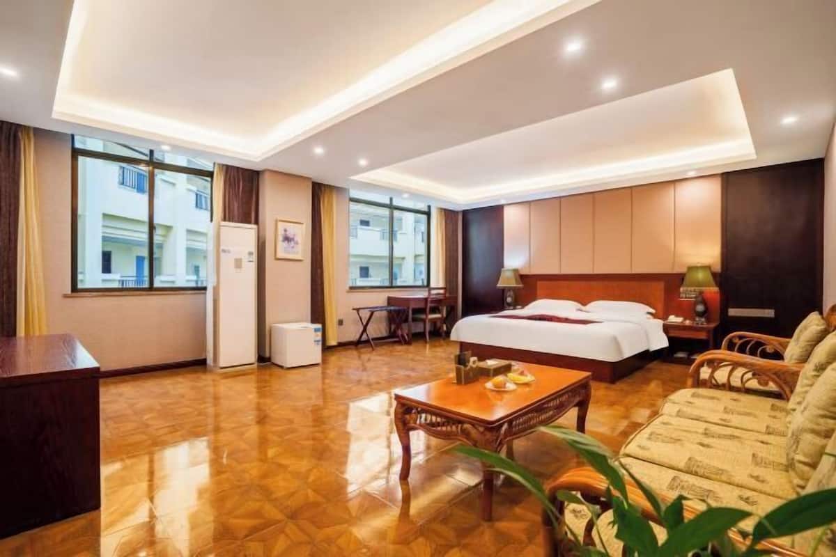Een hotelkamer met een bed, een bureau, een stoel, een salontafel en uitzicht.