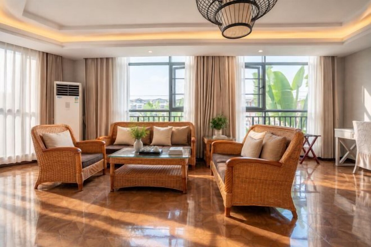 A spacious living area with a central coffee table, two sofas, and a dining table.
