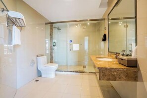 A modern bathroom with a glass-enclosed shower, a toilet, and a vanity with a sink and mirror.