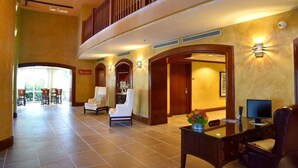A spacious lobby with a high ceiling, a balcony, and a reception desk with chairs. - SF 1Bed 1Bath Steps to Marina & CocoWalk in Grove (Miami)