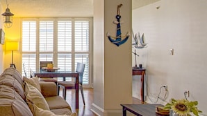 A living room with a sofa, a dining table, and a wall-mounted anchor decoration. - SF 1Bed 1Bath Steps to Marina & CocoWalk in Grove (Miami)