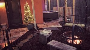 Ein Außenbereich mit einer Terrasse, einem Feuerkorb, einem Billardtisch und einem Weihnachtsbaum.