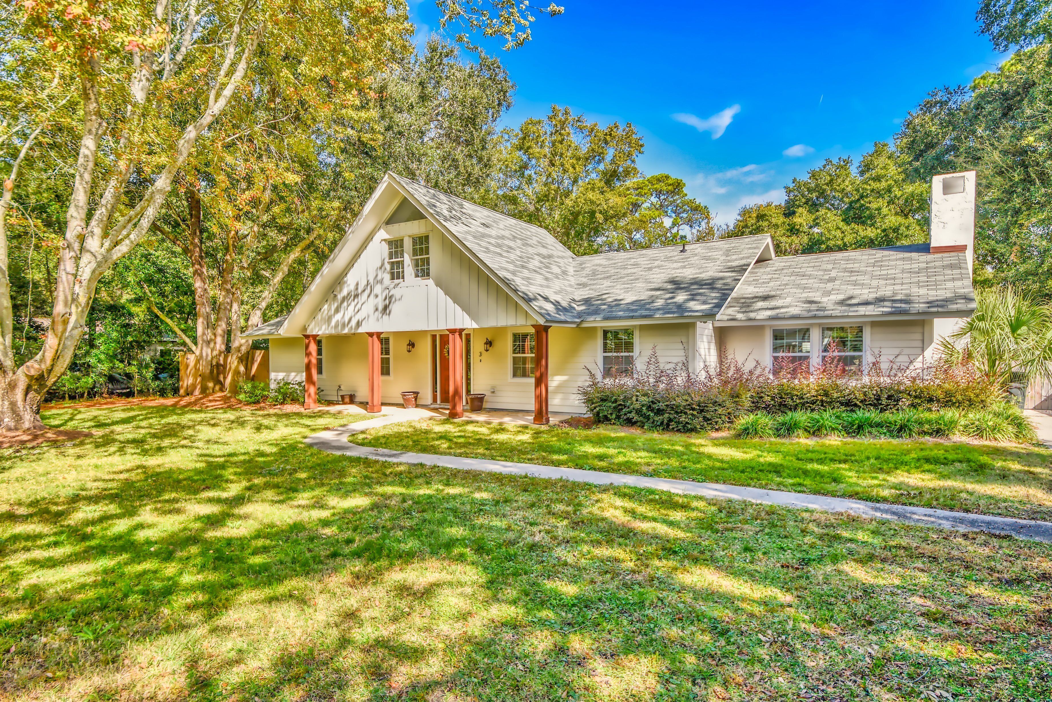 A two-story house with a gabled roof, a front porch, and a well-maintained lawn.
