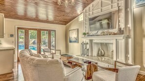 A spacious living room with a large sectional sofa, a dining area with a glass-top table, and a kitchen with a large island. - 2-Min Walk to Beach, Free Pool and Spa Heat, Family & Dog-Friendly, Sleeps 17, Kids' Loft (Hilton Head Island)