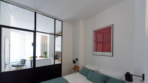 Un dormitorio con cama, ventana, escritorio y silla.