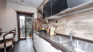 Une cuisine moderne dotée d’une cuisinière intégrée, d’un évier en acier inoxydable et de meubles de rangement en bois.