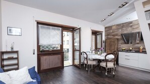 Un appartement moderne comprenant un coin repas, une cuisine et un balcon.