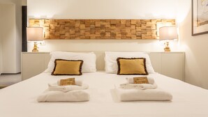 A hotel room with a large bed, two bedside tables, and a wooden headboard.