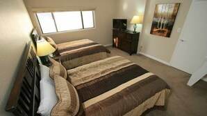 A bedroom with two beds, a dresser, a TV, and a painting on the wall. - 17 Vail Road Condos Short Walk to Vail Village and Gondola One by RedAwning (Vail)