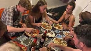 A group of people sitting around a table with plates of food and drinks. - Piggy Hostel Varkala (Varkala)