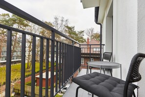 A balcony with a black metal railing, a round table, and two chairs. - Apartamenty Swinoujscie - Villa 44 (Swinoujscie)