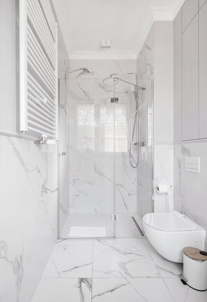 A modern bathroom with a glass-enclosed shower, a white bathtub, and marble flooring. - Apartamenty Swinoujscie - Villa 44 (Swinoujscie)