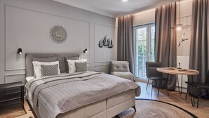 A modern bedroom with a large bed, a small table, and a chair. - Apartamenty Swinoujscie - Villa 44 (Swinoujscie)