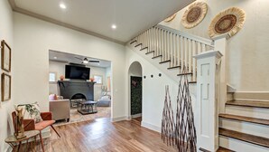 A spacious living area with a fireplace, a staircase, and a dining area.
