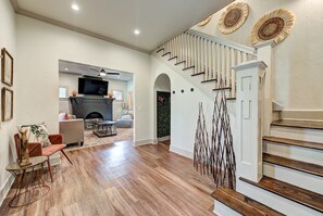 A spacious living area with a fireplace, a staircase, and a dining area. - Cottage Chic- Less than 5 mins to Plaza District (Oklahoma City)