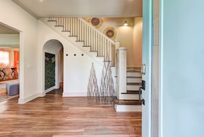 A staircase with wooden steps and white railings, leading to a landing with a decorative wall piece. - Cottage Chic- Less than 5 mins to Plaza District (Oklahoma City)