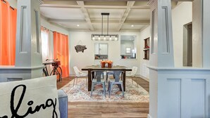 A dining area with a wooden table, chairs, and a chandelier.