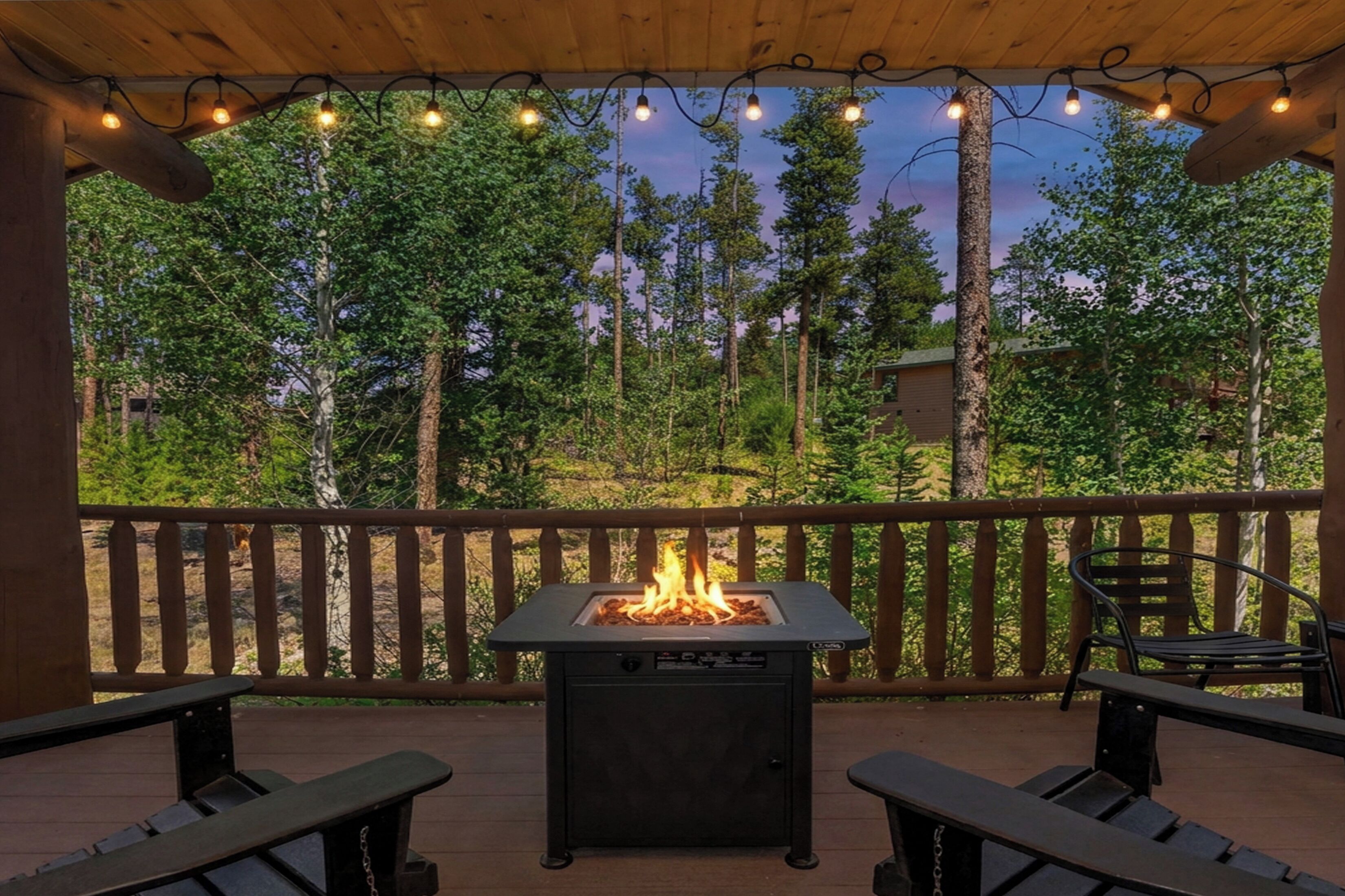 Une terrasse extérieure dotée d’un foyer, de rampes en bois et de deux bancs.