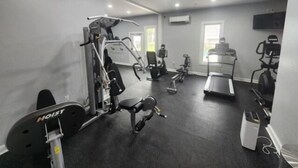 A gym with various exercise equipment including a treadmill, stationary bikes, and weight machines.